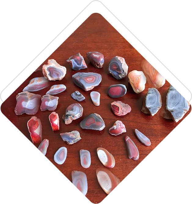 A wooden table topped with lots of different colored rocks.