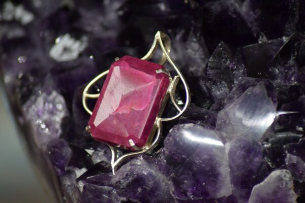 A red stone sitting on top of purple rocks